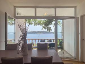 a dining room with a table and a view of the water at Prizba Tomas One in Blato