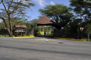 un parking avec un bâtiment au milieu d'une route dans l'établissement Lake Naivasha Sopa Resort, à Naivasha