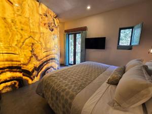 a bedroom with a large bed and a stone wall at Castello di Carlo - Suite Carlo IV in Santeagueda