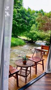Ban Mae Sapok Noi3pok-Riverside maewangjinxiang的阳台配有两把椅子和一张桌子,还享有河流美景。 更多37张照片