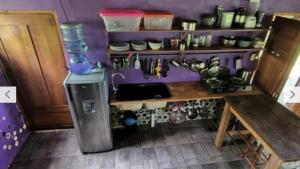 小玉米岛Casa Botella的厨房配有柜台和带工具的架子