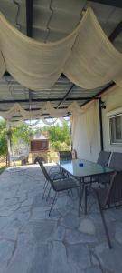 a patio with a table and chairs under a tent at Aristoteles Apartments in Olympiada