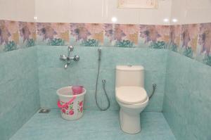a bathroom with a toilet and a bucket at Lilly's Valley Resort in Kodaikānāl