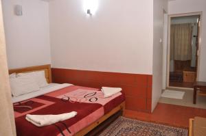 a bedroom with a bed with a red tiled floor at Lilly's Valley Resort in Kodaikānāl