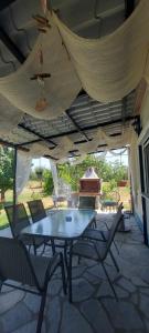 a patio with a table and chairs under a tent at Aristoteles Apartments in Olympiada