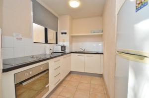 a kitchen with white cabinets and a counter top at Riverview Holiday Apartment 28 - Kalbarri WA in Kalbarri