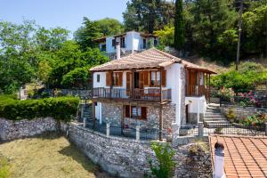 a small house on a hill with a stone wall at Etherio House in Skala Sotiros