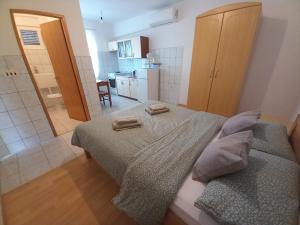 ein Schlafzimmer mit einem Bett mit zwei Handtüchern darauf in der Unterkunft Peša Holiday Apartments in Zaton