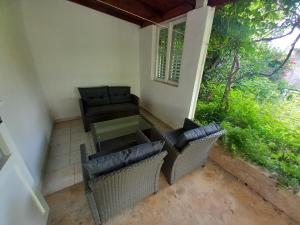 eine Terrasse mit Stühlen, einem Tisch und einem Sofa in der Unterkunft Peša Holiday Apartments in Zaton