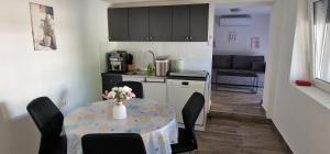 a kitchen with a table with a vase of flowers on it at Antonija in Cesarica