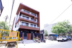 Un grand bâtiment avec des personnes assises à l'extérieur dans l'établissement THE ROYAL VILLA - Noida Sector 70, à Noida