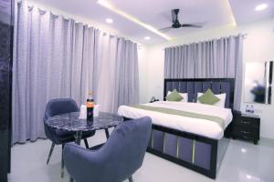 une chambre avec un lit, une table et des chaises dans l'établissement THE ROYAL VILLA - Noida Sector 70, à Noida 51 autres photos