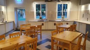a kitchen with wooden tables and chairs and windows at 12 Premium Camping Pod "Fehmarn" in Silberstedt +8 photos