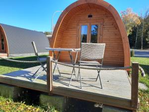 Silberstedt07 Premium Camping Pod "Norderoog"的木制甲板配有两把椅子和帐篷