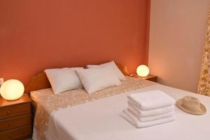 a bedroom with a bed with towels and two lamps at Appartement entier in Paralia Katerinis