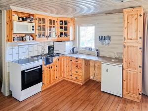 a kitchen with wooden cabinets and white appliances at 6 person holiday home in Flatanger in Lauvsnes