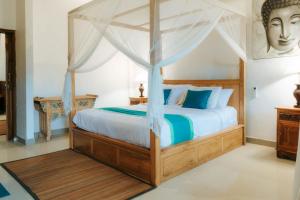 a bedroom with a large bed with a canopy at Tap One Villa Ubud in Ubud