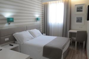 a hotel room with a white bed and white walls at Seculo Soft in Porto