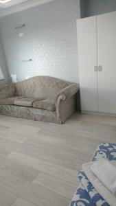 a living room with a brown couch in a room at Bon Mary Hotel in Astana