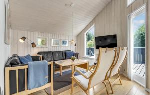 a living room with a couch and a table at Holiday Home Mælkebøttevej Væggerløse Ii in Marielyst