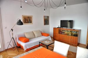a living room with a couch and a tv at Apartman Gema in Skrad