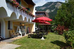 a patio with tables and umbrellas next to a building at Residence Granvara in Ortisei