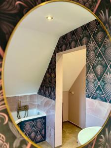 eine Spiegelreflexion eines Badezimmers mit blauen und violetten Fliesen in der Unterkunft Villa Pauline - FeWo Bretagne in Bad Sooden-Allendorf