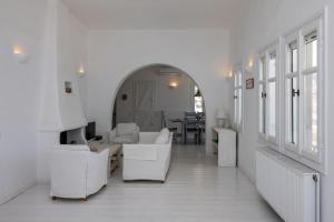 a white living room with white furniture and a table at Villa Tanaos in Tinos in Kardiani