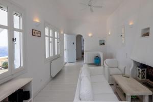 a white living room with white furniture and windows at Villa Tanaos in Tinos in Kardiani