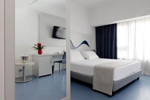 una camera da letto con un letto e una scrivania con un computer di Hotel Poseidon a Torre del Greco Altre 143 foto