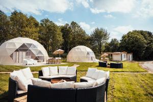 a group of tents with couches and chairs in a field at Glamping Blessed - Adult Only in Best