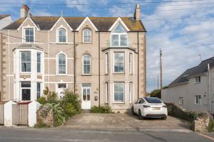 a house with a car parked in front of it at Wylfa The Upper House & The Hide By Birch Stay in Rhosneigr