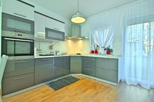 a kitchen with gray cabinets and a large window at Rooms Hana Rovinj in Rovinj