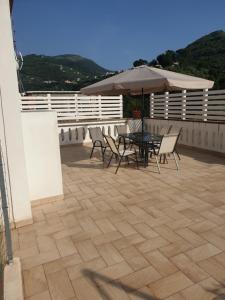 a patio with a table and chairs and an umbrella at Fradalisa Delizioso monolocale a Vico Equense in Vico Equense