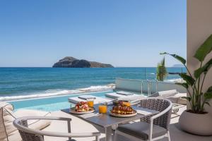 jadalnia ze stołem i krzesłami i widokiem na ocean w obiekcie Marika Beach Hotel w mieście Platanias