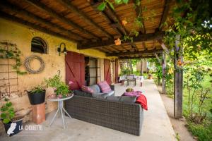 a patio with a couch under a pergola at Gîte in Castex