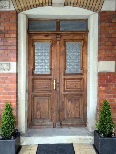a wooden door in a brick building with two potted plants at Ferienwohnung Coburg, familienfreundlich und stilvoll in Coburg