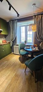 a living room with a table and chairs and a kitchen at LUX-Апартаменты London Style в центре Усть-Каменогорска in Ustʼ-Kamenogorsk +11 photos