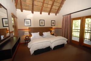 a bedroom with a large bed with white sheets at Emerald Resort & Casino in Vanderbijlpark +104 photos