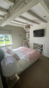 a bedroom with a large bed and a flat screen tv at Spenford House 1640 listed house Idilic Location pub walking distance in Shrewsbury +136 photos