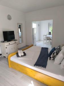 ein großes Bett in einem weißen Zimmer mit einem TV in der Unterkunft Apartments Jamice in Novi Vinodolski