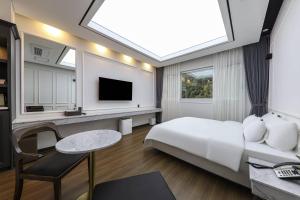 a hotel room with a bed and a tv at Hotel Demer Mokpo in Mokpo