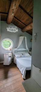 a bedroom with a white bed and a window at B&B L'Usignolo in Ascoli Piceno
