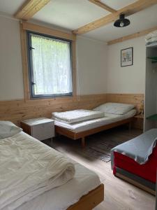a room with two beds and a window at Retro chatky Hůrka Lipno in Horní Planá