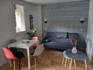 a living room with a couch and a table and chairs at ArriuMage in Bielle