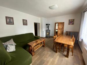 a living room with a green couch and a wooden table at U Elišky in Rapšach +4 photos