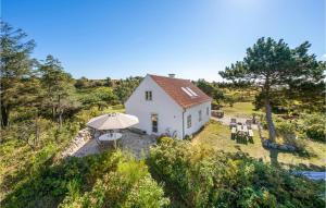 a small white house with an umbrella on a hill at Awesome Home In Knebel With Kitchen in Knebel +24 photos