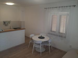 a kitchen with a table and chairs in a room at Apartment By The Sea Marko in Banj