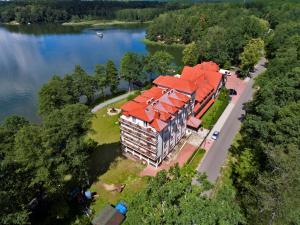 an aerial view of a large building with an orange roof at Hotel Nidzki in Ruciane-Nida