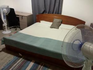 a bedroom with a bed with a fan on it at Atakwame Island in Atimpoko +2 photos